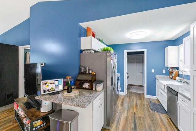 kitchen featuring white cabinetry, light stone counters, sink, stainless steel dishwasher, and light hardwood / wood-style floors