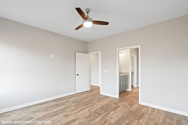 unfurnished bedroom featuring light wood-type flooring, ensuite bathroom, and ceiling fan