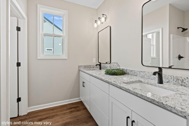 bathroom with hardwood / wood-style floors, vanity, and walk in shower