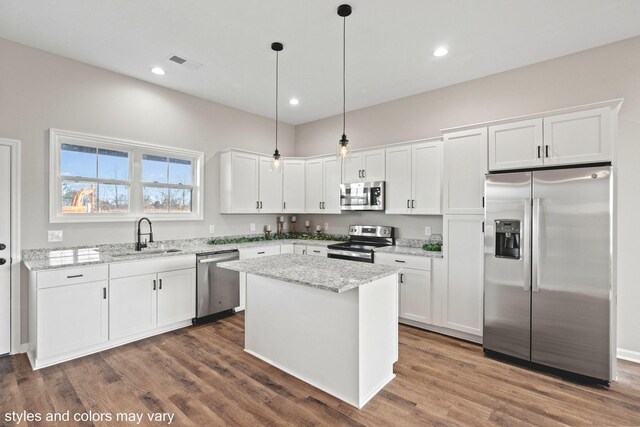 kitchen featuring sink, decorative light fixtures, a kitchen island, white cabinetry, and stainless steel appliances