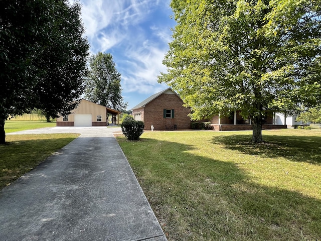 view of front of home featuring a garage, a front lawn, and an outdoor structure