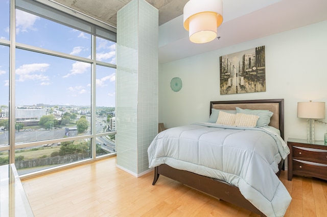 bedroom featuring floor to ceiling windows, multiple windows, and light hardwood / wood-style floors