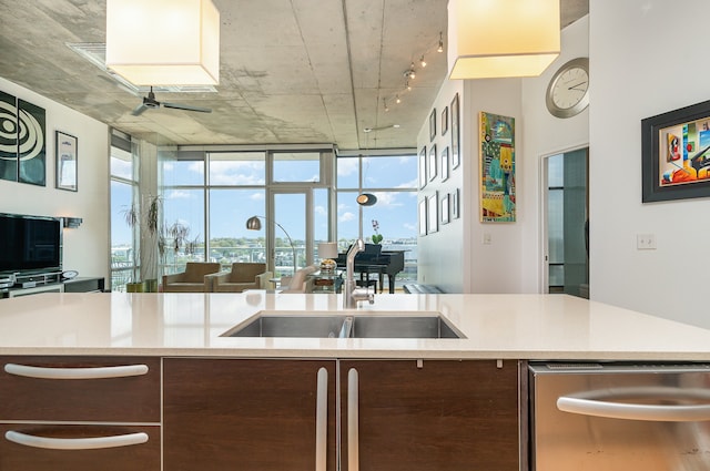 kitchen with dishwasher, sink, light stone countertops, ceiling fan, and expansive windows