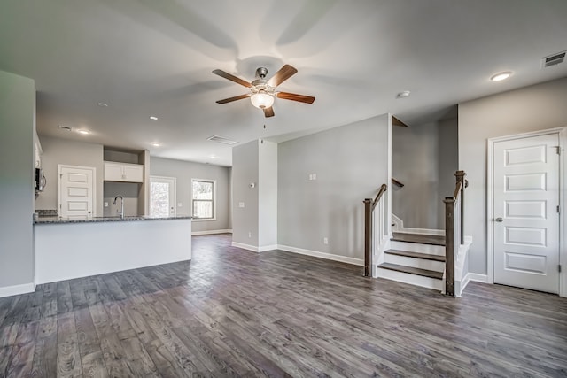 unfurnished living room with dark wood-type flooring, sink, and ceiling fan