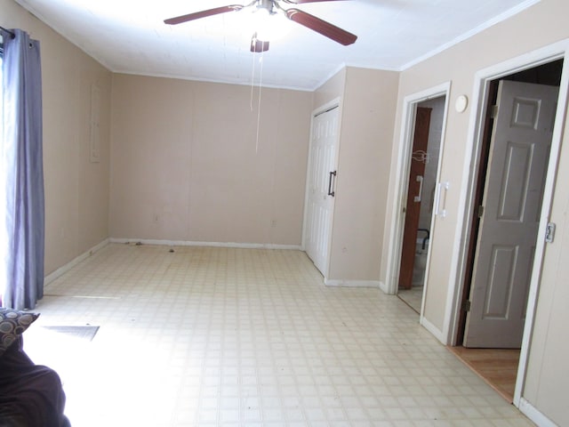 unfurnished room with baseboards, light floors, a ceiling fan, and crown molding