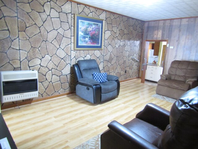 living room featuring hardwood / wood-style flooring, wood walls, and heating unit