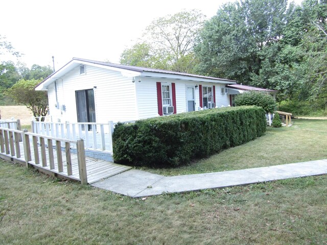 view of front of home with cooling unit and a front yard