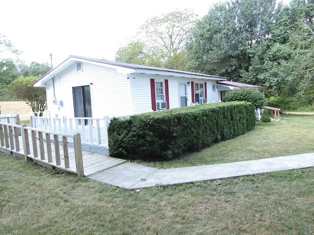 view of front facade featuring a deck, a front lawn, and cooling unit