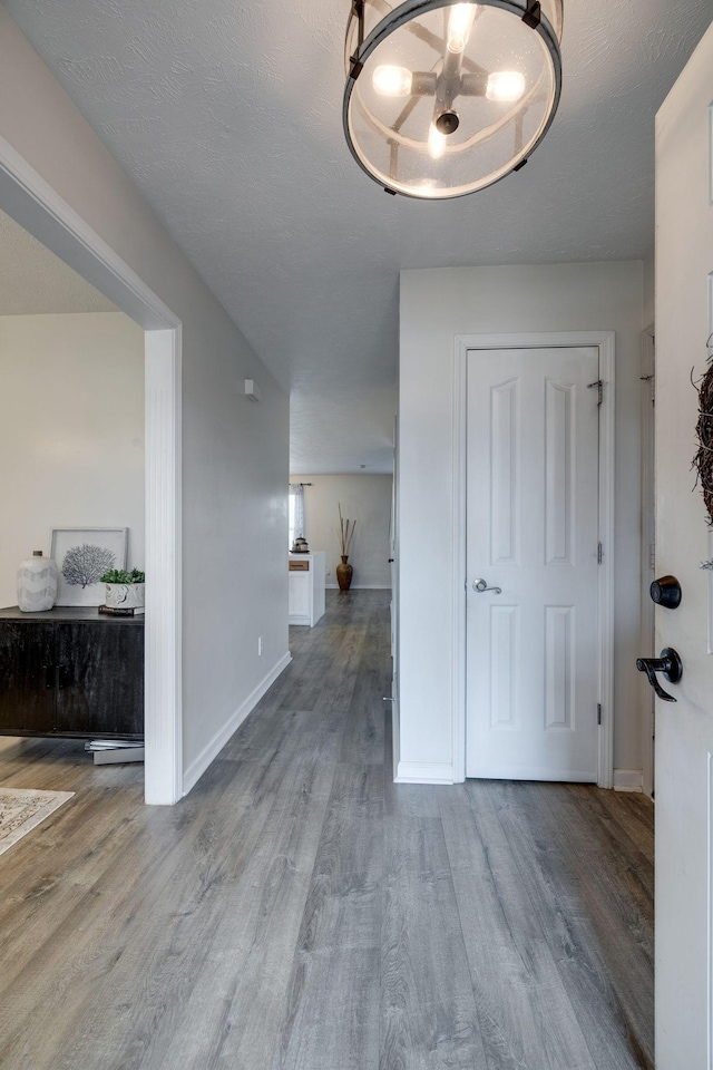 corridor featuring a textured ceiling and hardwood / wood-style flooring