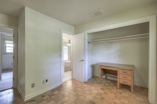 unfurnished bedroom with light parquet flooring, multiple windows, and a closet