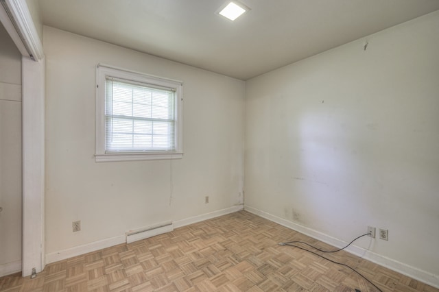 empty room with light parquet floors and baseboard heating