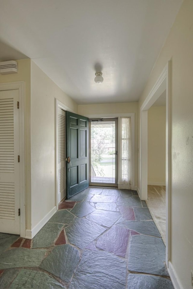 entryway featuring stone tile floors and baseboards