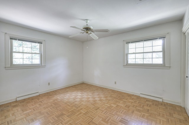 spare room featuring light parquet flooring, ceiling fan, and a baseboard radiator