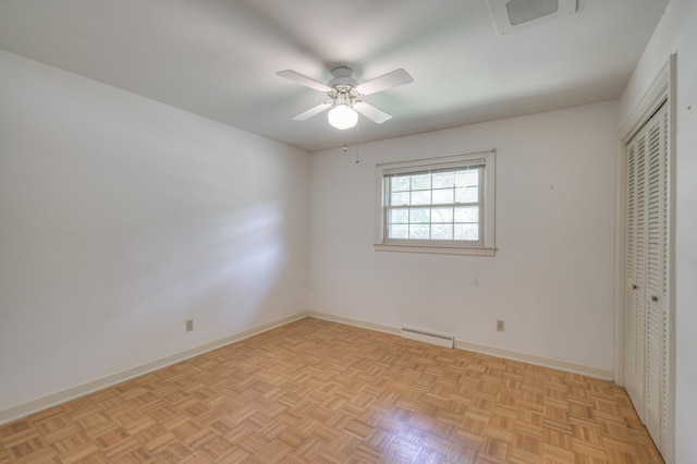 unfurnished bedroom with ceiling fan, a baseboard radiator, and light parquet floors