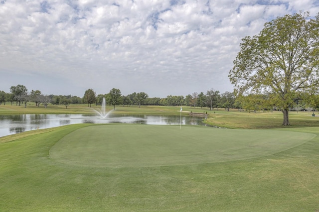 view of property's community with a water view, golf course view, and a lawn