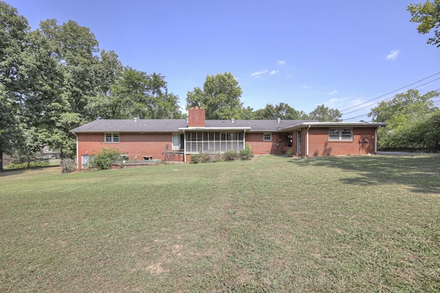 view of front of home featuring a front lawn and a sunroom