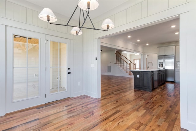 6816 Springwater St, Smyrna, TN 37167 - kitchen featuring stainless steel appliances, light countertops, light wood-style floors, a center island with sink, and baseboards