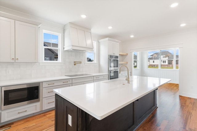 6816 Springwater St, Smyrna, TN 37167 - kitchen with built in microwave, custom exhaust hood, black electric cooktop, stainless steel double oven, and light countertops