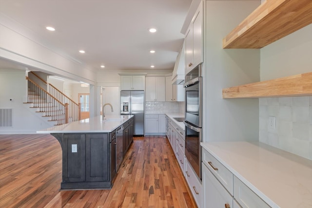 6816 Springwater St, Smyrna, TN 37167 - kitchen with appliances with stainless steel finishes, light countertops, a sink, light wood-type flooring, and backsplash