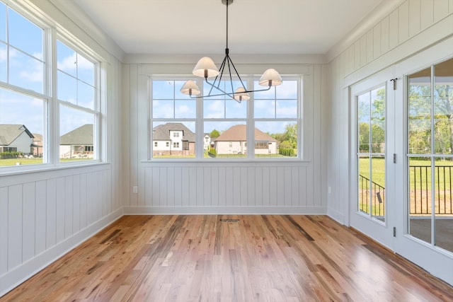 6816 Springwater St, Smyrna, TN 37167 - unfurnished dining area featuring a chandelier, light wood-type flooring, healthy amount of natural light, baseboards, and wooden walls