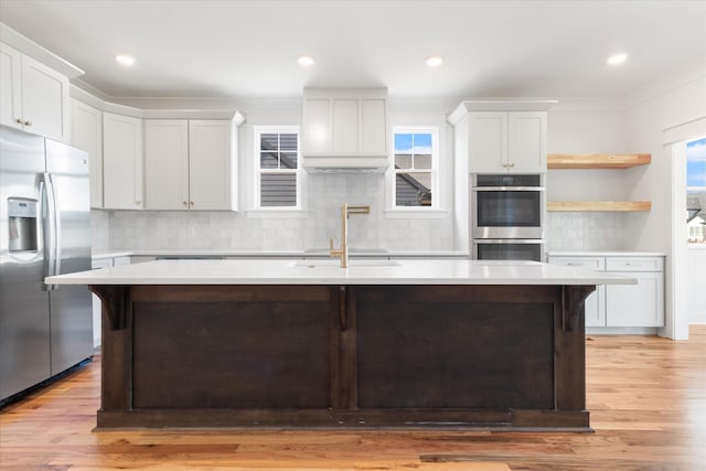 6816 Springwater St, Smyrna, TN 37167 - kitchen featuring appliances with stainless steel finishes, a center island with sink, light countertops, light wood-type flooring, and recessed lighting