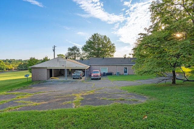 back of house with a lawn and a carport