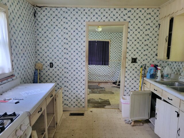 bathroom featuring tile patterned flooring, crown molding, and sink