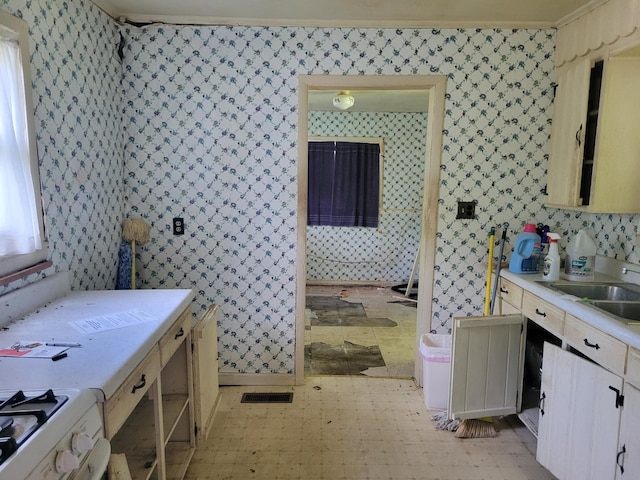 bathroom with tile patterned floors, a sink, and wallpapered walls