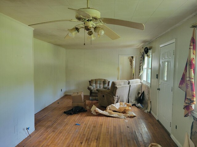 misc room with wood-type flooring, ornamental molding, and ceiling fan