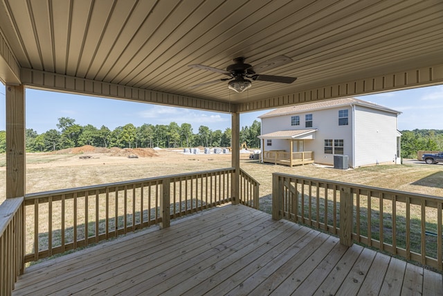 wooden deck featuring ceiling fan, cooling unit, and a lawn