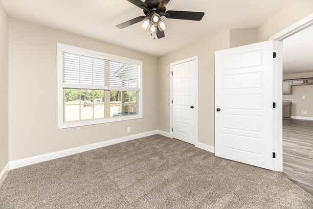 unfurnished bedroom with ceiling fan and carpet floors