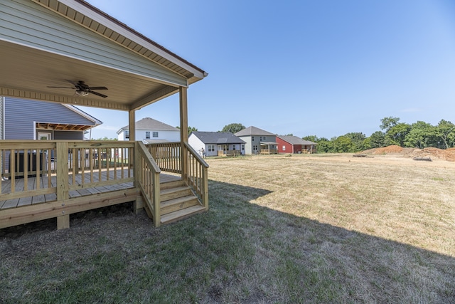 view of yard with ceiling fan and a deck