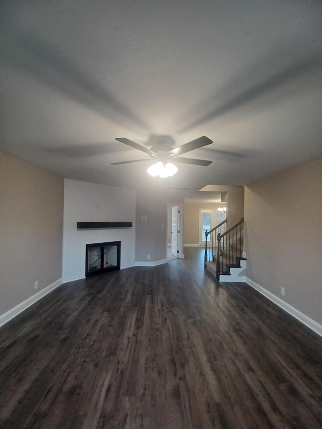 unfurnished living room featuring ceiling fan and dark hardwood / wood-style floors