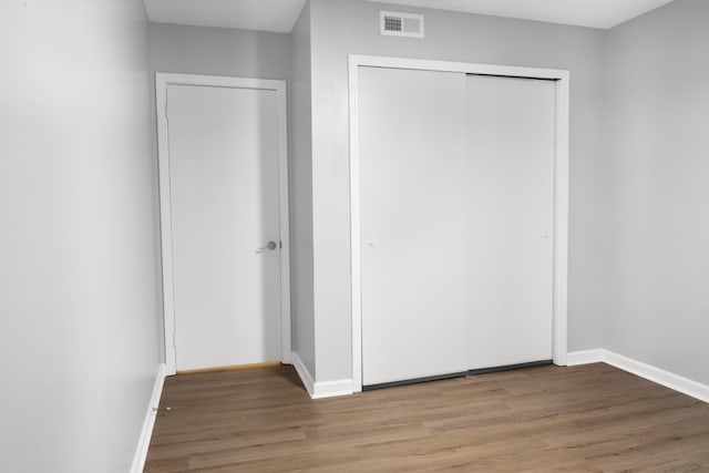 unfurnished bedroom featuring hardwood / wood-style flooring and a closet