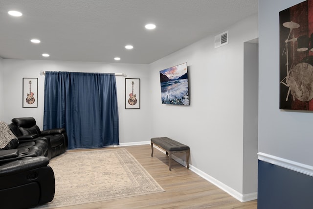 interior space with a textured ceiling and light hardwood / wood-style floors