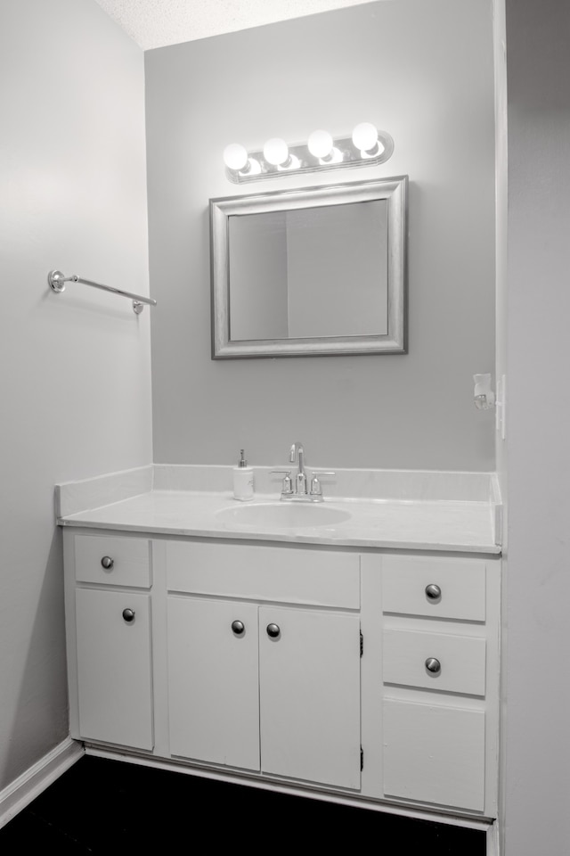 bathroom featuring a textured ceiling and vanity