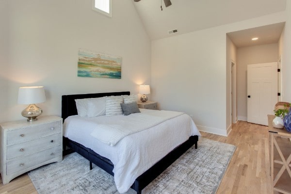 bedroom with light wood-type flooring, lofted ceiling, and ceiling fan