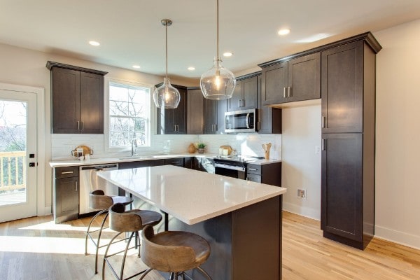 kitchen with plenty of natural light, hanging light fixtures, appliances with stainless steel finishes, and a kitchen island