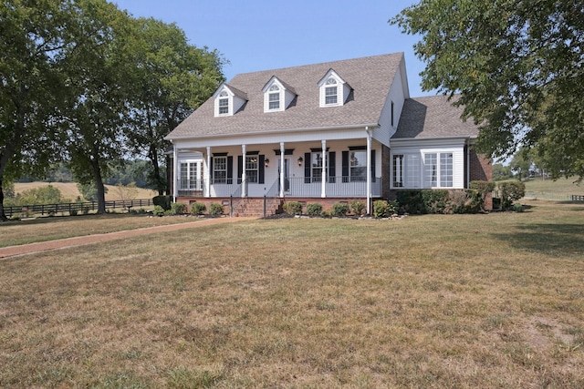 cape cod-style house featuring covered porch and a front yard