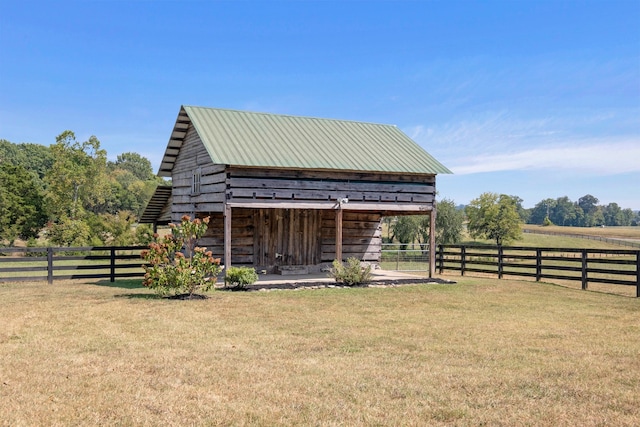 view of outdoor structure with a lawn and a rural view