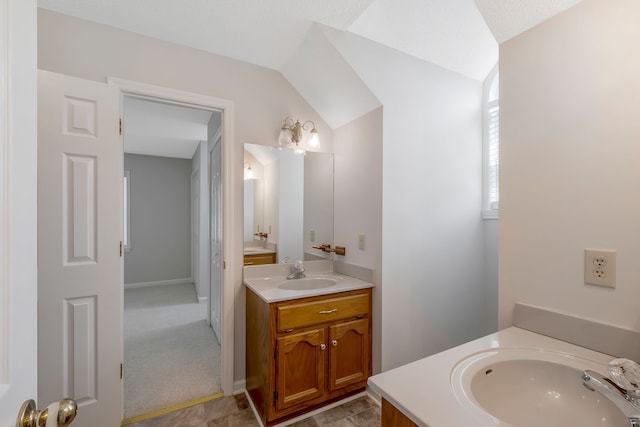 bathroom featuring a textured ceiling, vanity, and vaulted ceiling