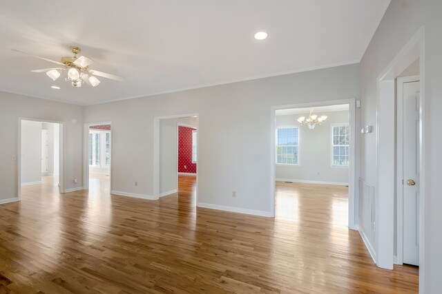 unfurnished room featuring ceiling fan with notable chandelier, light hardwood / wood-style floors, and ornamental molding