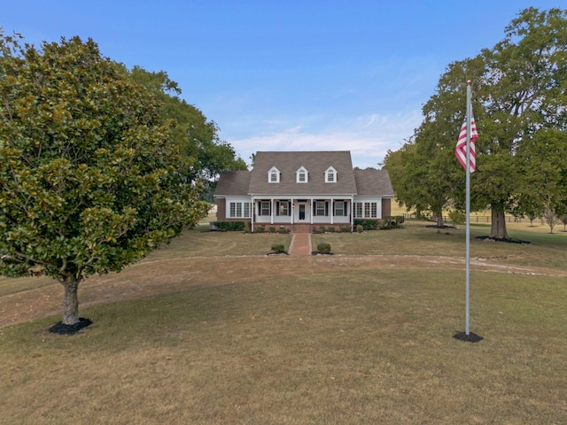 cape cod house with covered porch and a front yard