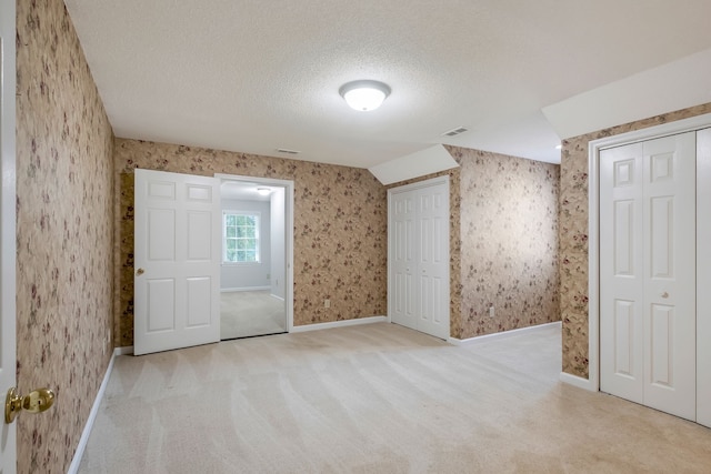 carpeted empty room with a textured ceiling