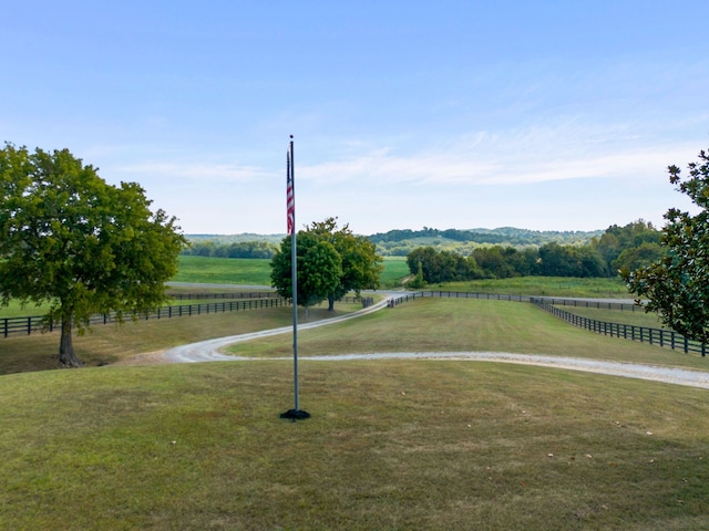 view of property's community featuring a lawn and a rural view