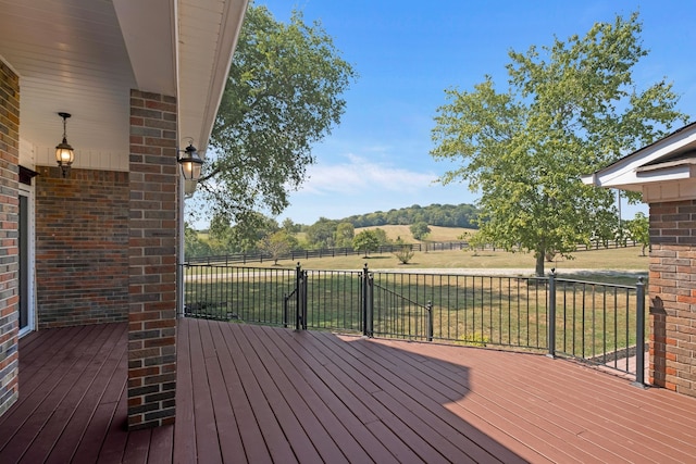 deck with a yard and a rural view