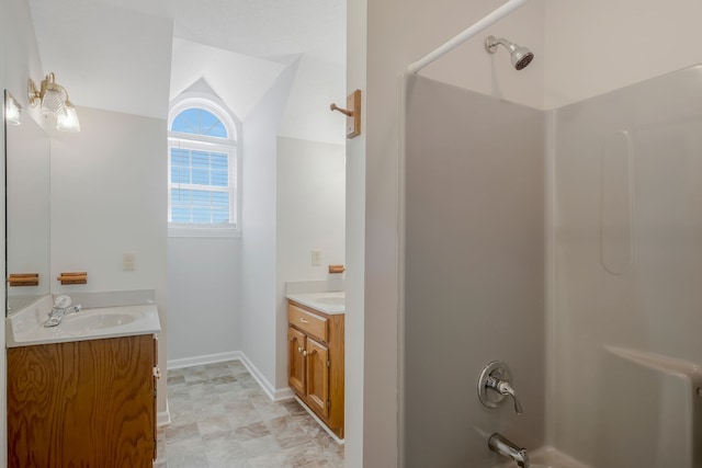 bathroom featuring vanity, vaulted ceiling, and shower / bathtub combination