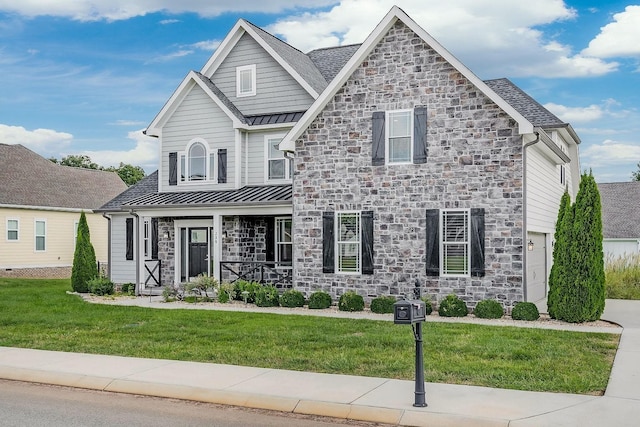 view of front of house with stone siding, metal roof, a standing seam roof, a porch, and a front yard