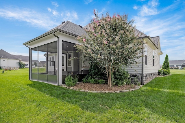 back of house with a yard and a sunroom