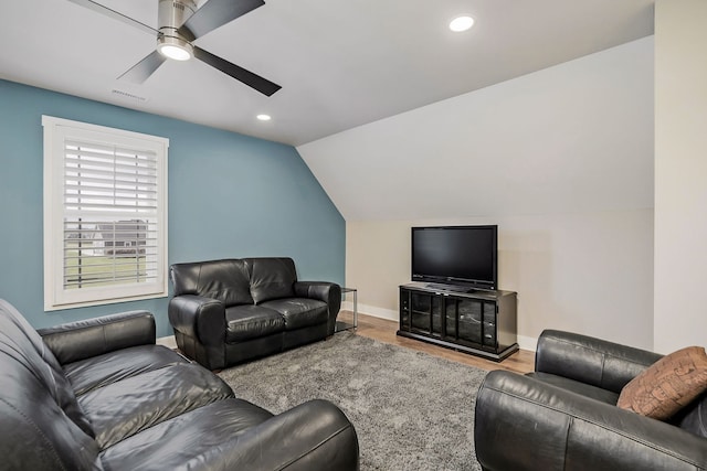 living room with ceiling fan, vaulted ceiling, and light hardwood / wood-style flooring